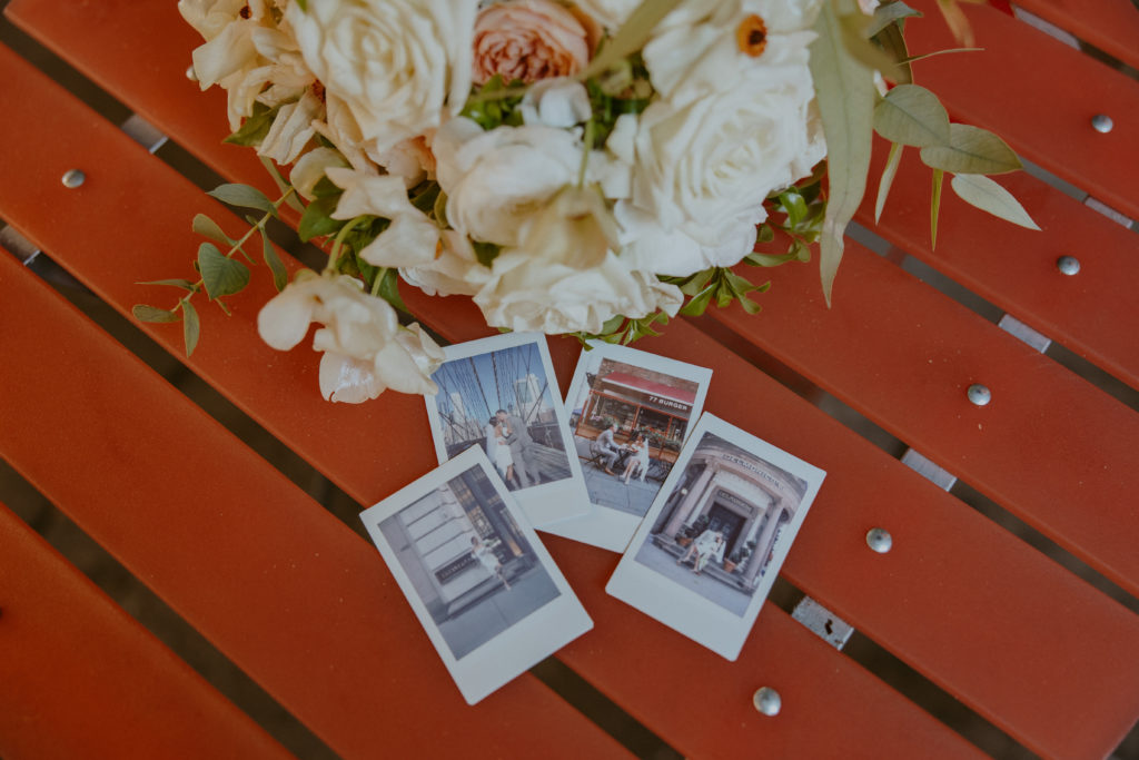 Polaroids of a wedding couple laying on a table.