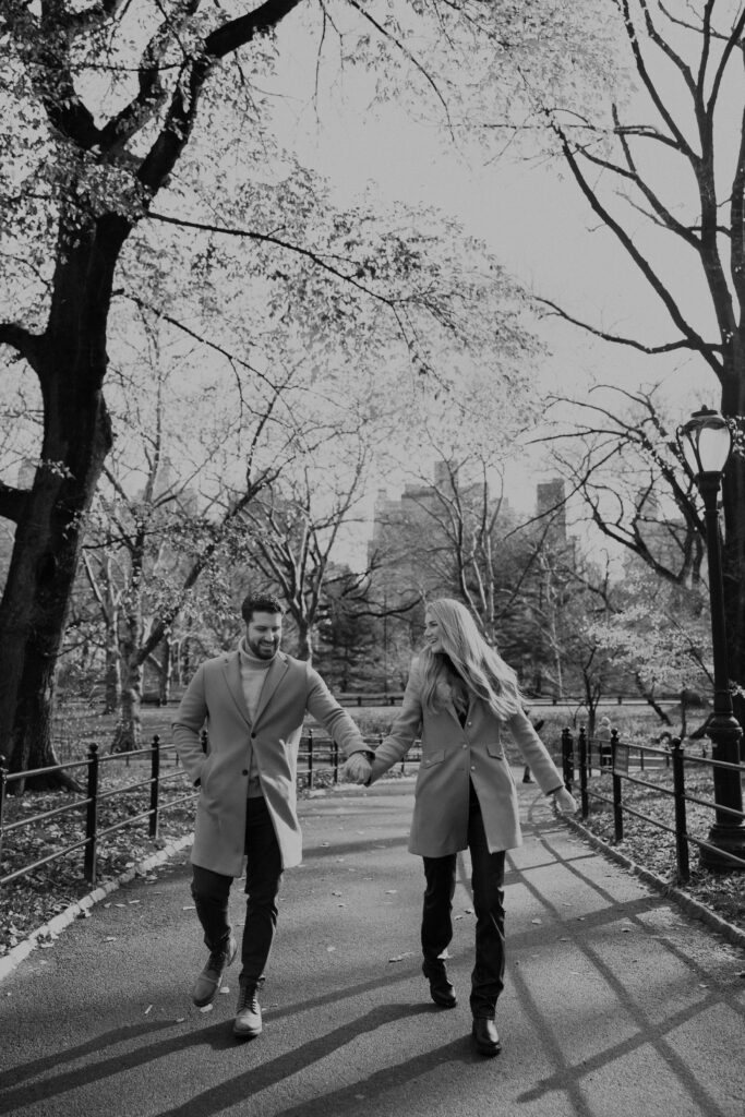 Couple strolls through central park after surprise proposal. 
